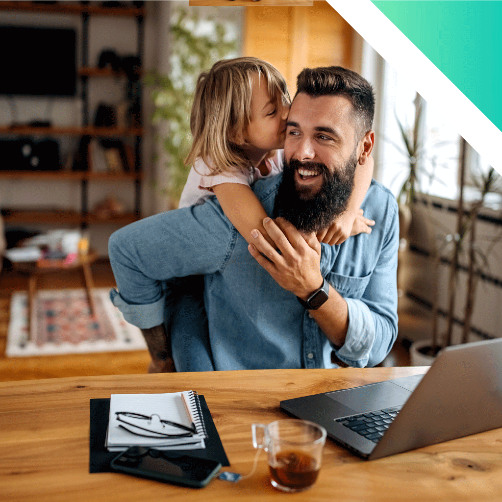 young child hugging dad working from home